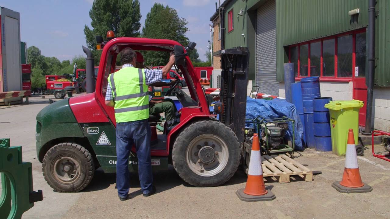 A TAD engineer alongside a rough terrain forklift fitted with an i-am unit