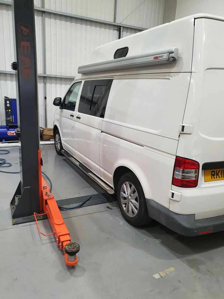 A van raised on the workshop ramp