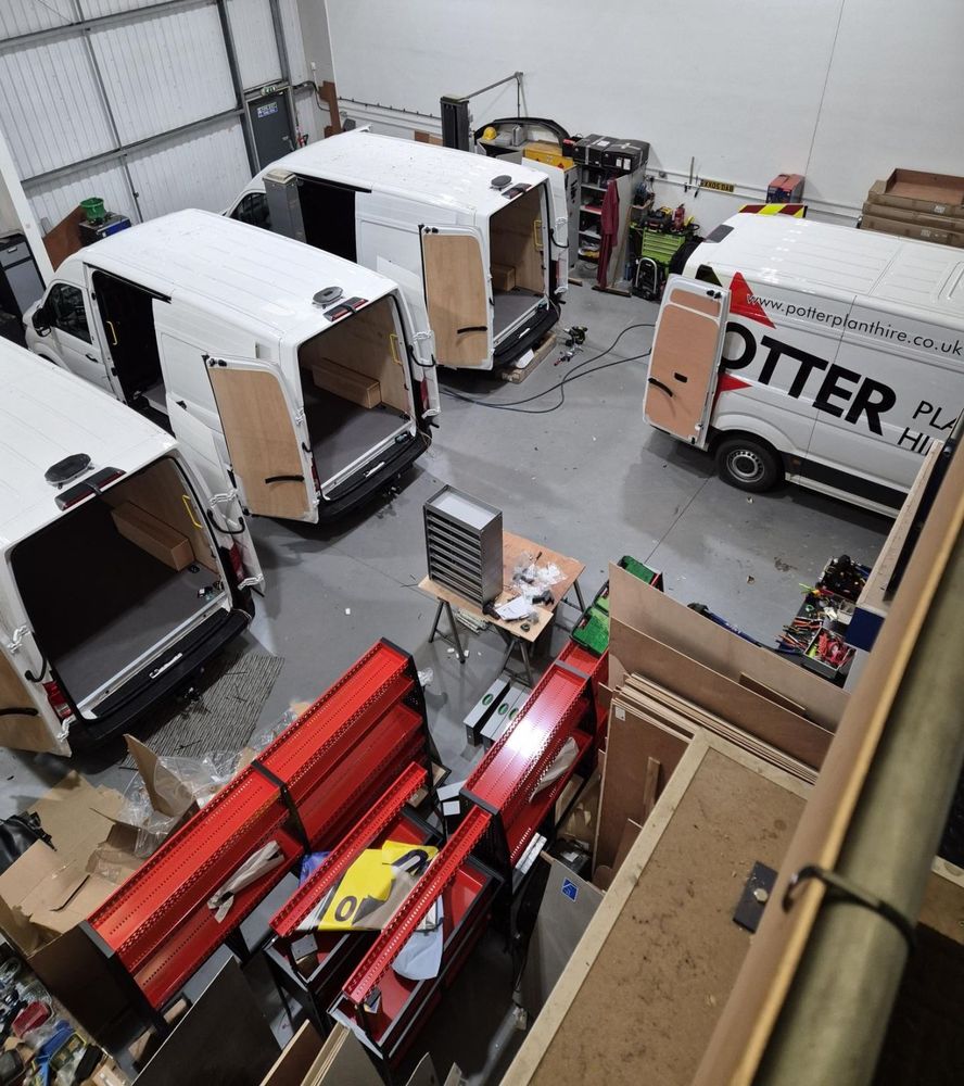 Racking components stacked beside a van in the workshop