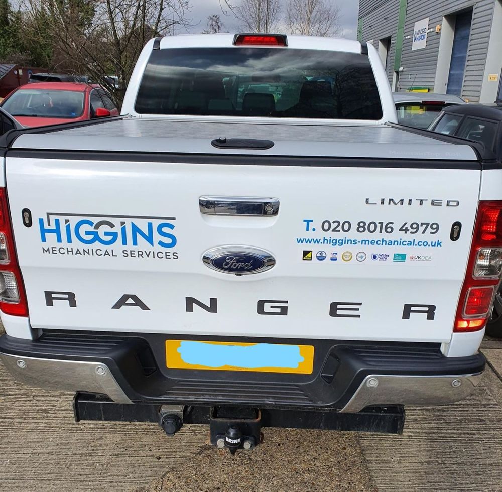 A liveried pickup truck at the back of the workshop